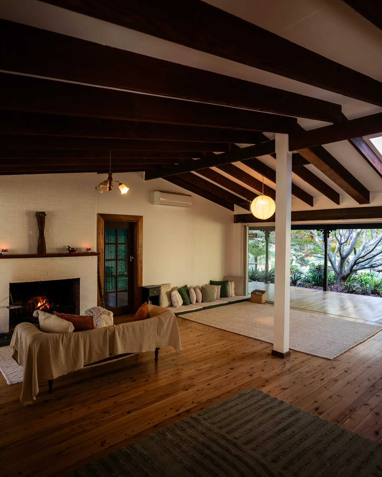 The shared hall with its fireplace, beams and garden doors
