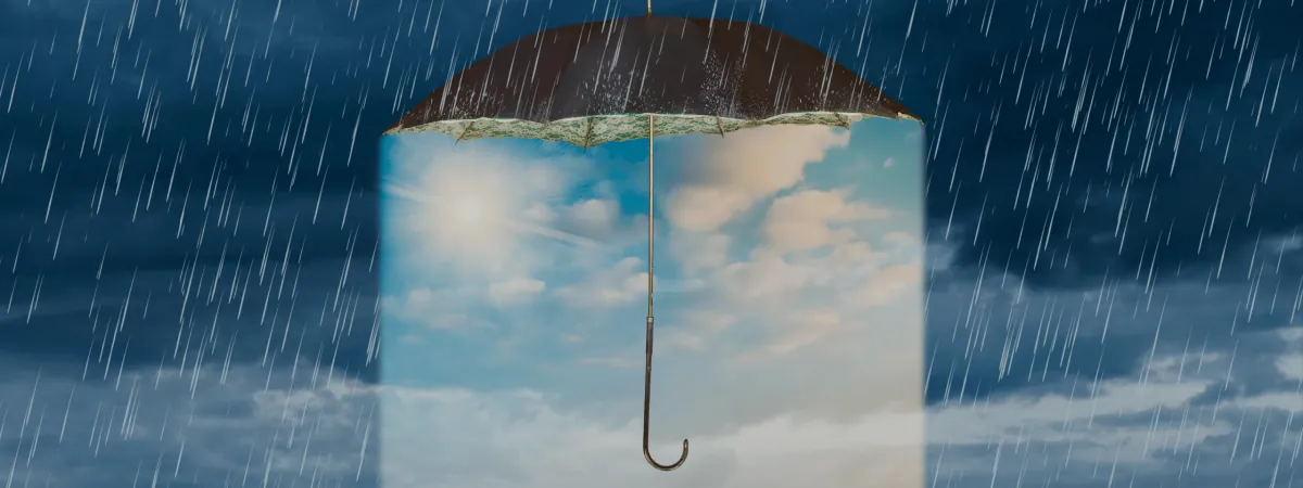 An umbrella holding a patch of blue sky in the rain