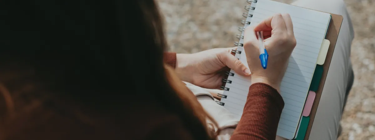A person writing in a notebook