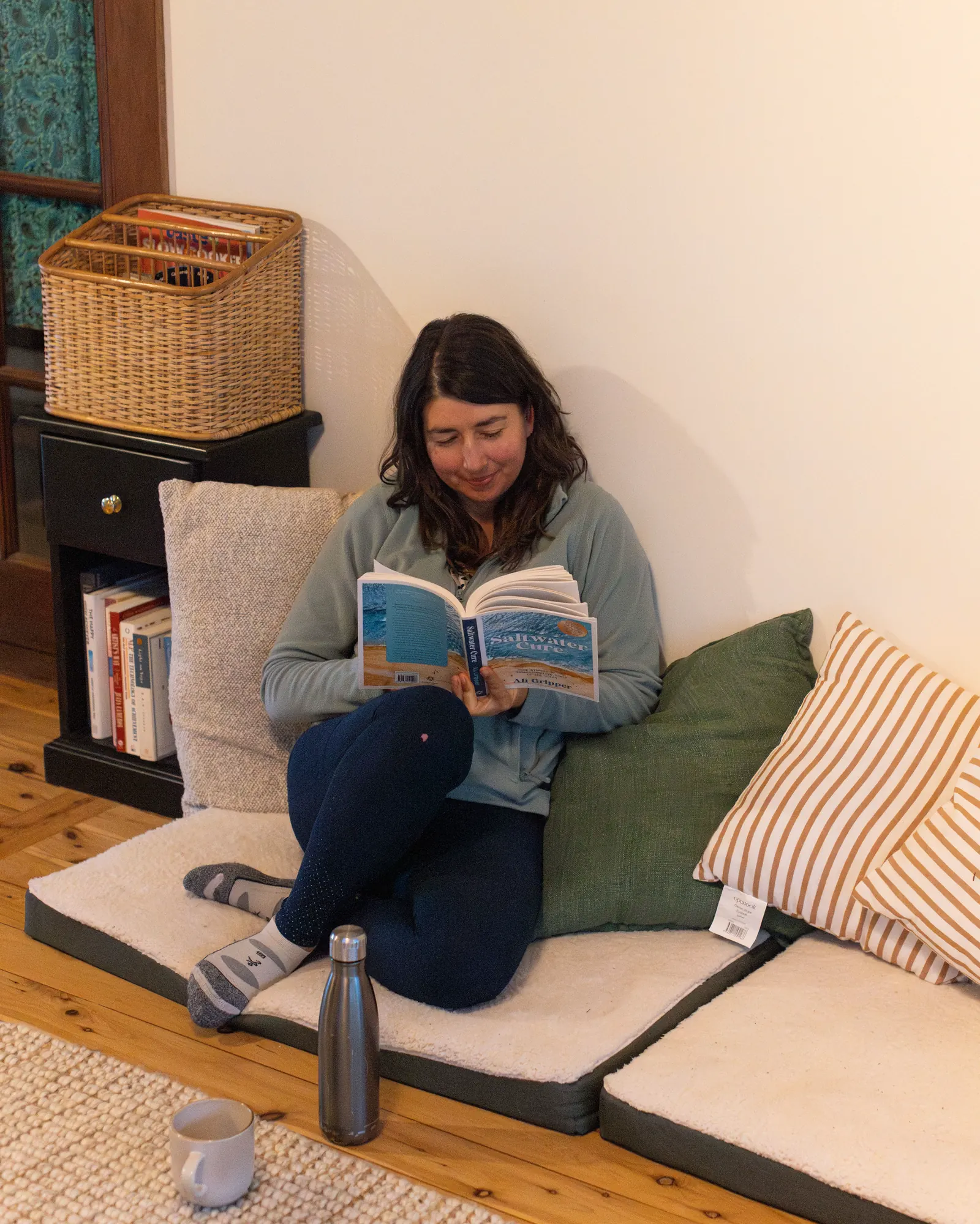 A guest reading on floor cushions in the lounge corner