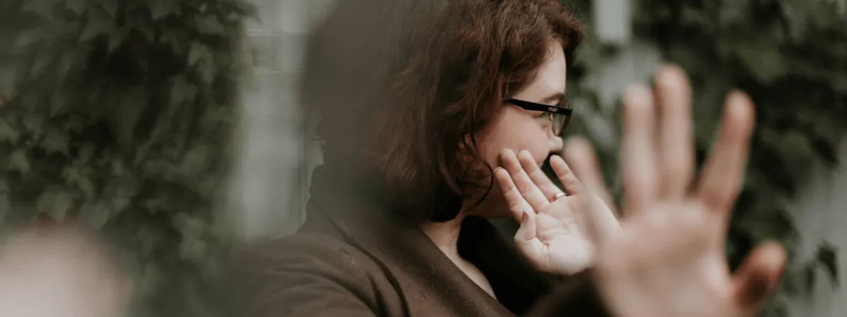 A woman holding up one hand