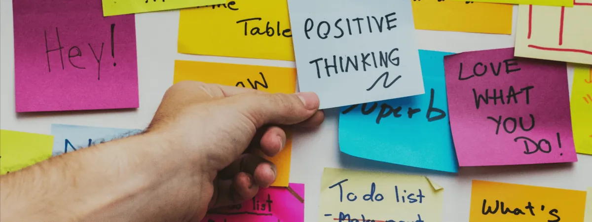 Sticky notes on a wall, one reading Positive Thinking